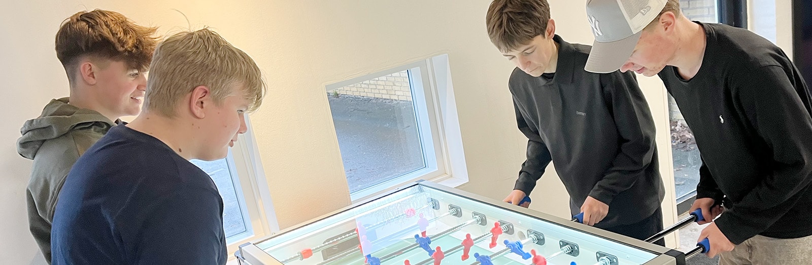En gruppe drenge får sig en rask kamp ved det nye bordfodboldbord i Assentoft Hallerne