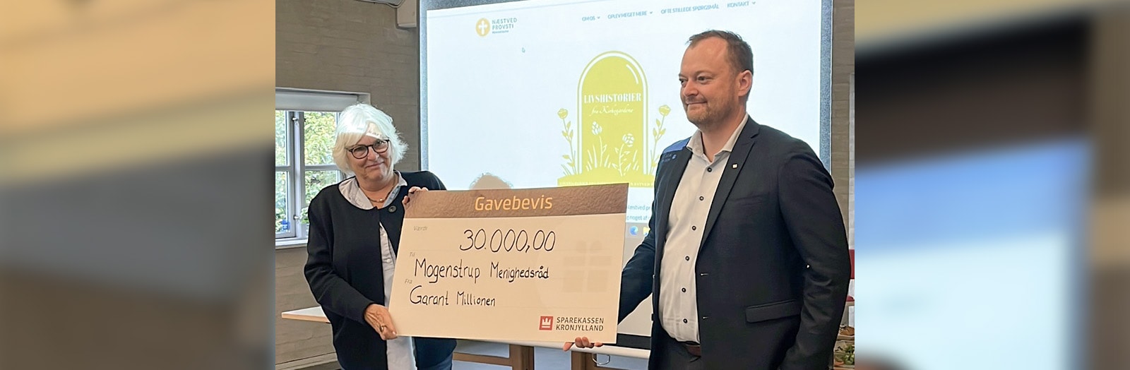 Erhvervskundechef Ulrik Hansen fra Sparekassen Kronjylland i Slagelse overrækker en donation til Næstelsø-Mogenstrup Menighedsråd til deres 'Fortællinger fra kirkegården'-projekt.